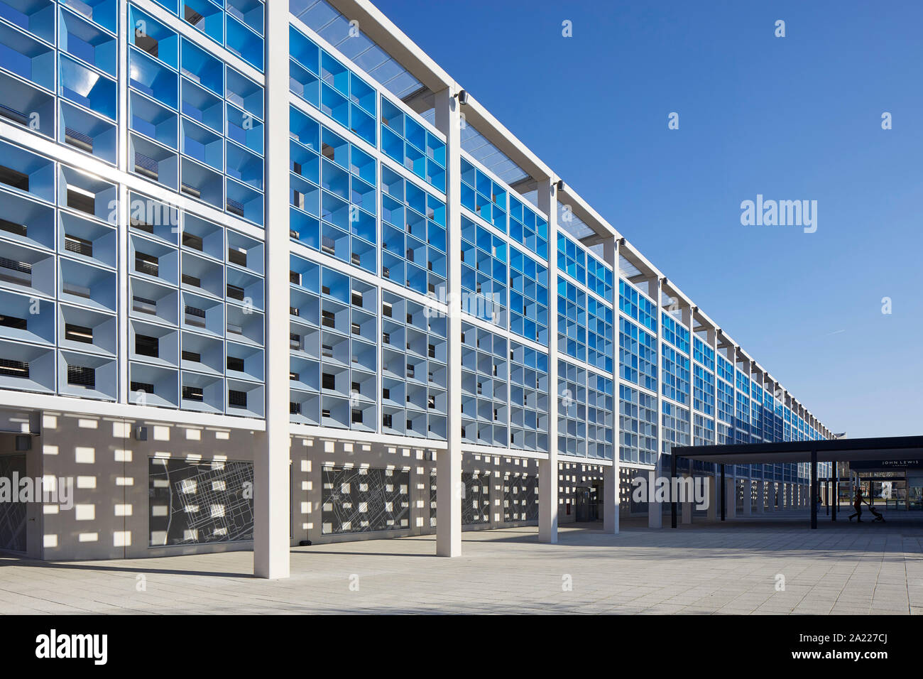 Oblique view along exterior facade with stone panels and perforated metal  screens. Centre MK, Milton Keynes, United Kingdom. Architect: Leslie Jones  A Stock Photo - Alamy