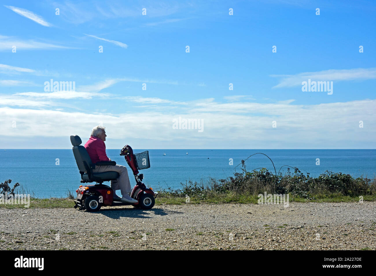 Highcliffe - Dorset - on the cliff path - contemplation - disabled man on mobile carriage Stock Photo