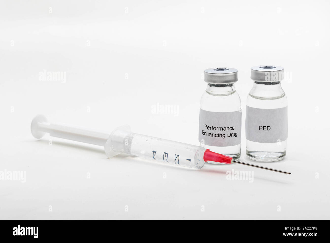 Medical concept showing medical 2 medical vials reading PED and Performance Enhancing Drug with a syringe Stock Photo
