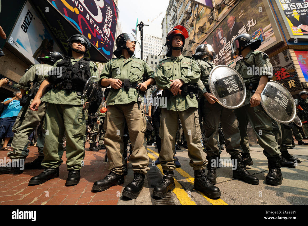 Hong Kong. 29 September, 2019. Illegal march by thousands of pro-democracy supporters from Causeway Bay to Government offices at Admiralty. Police unsuccessfully tried to stop march at start with teargas fired and scuffles. March marked the 5th anniversary of the start of the Umbrella Movement. Riot police control crowds in busy Causeway bay before march. Stock Photo