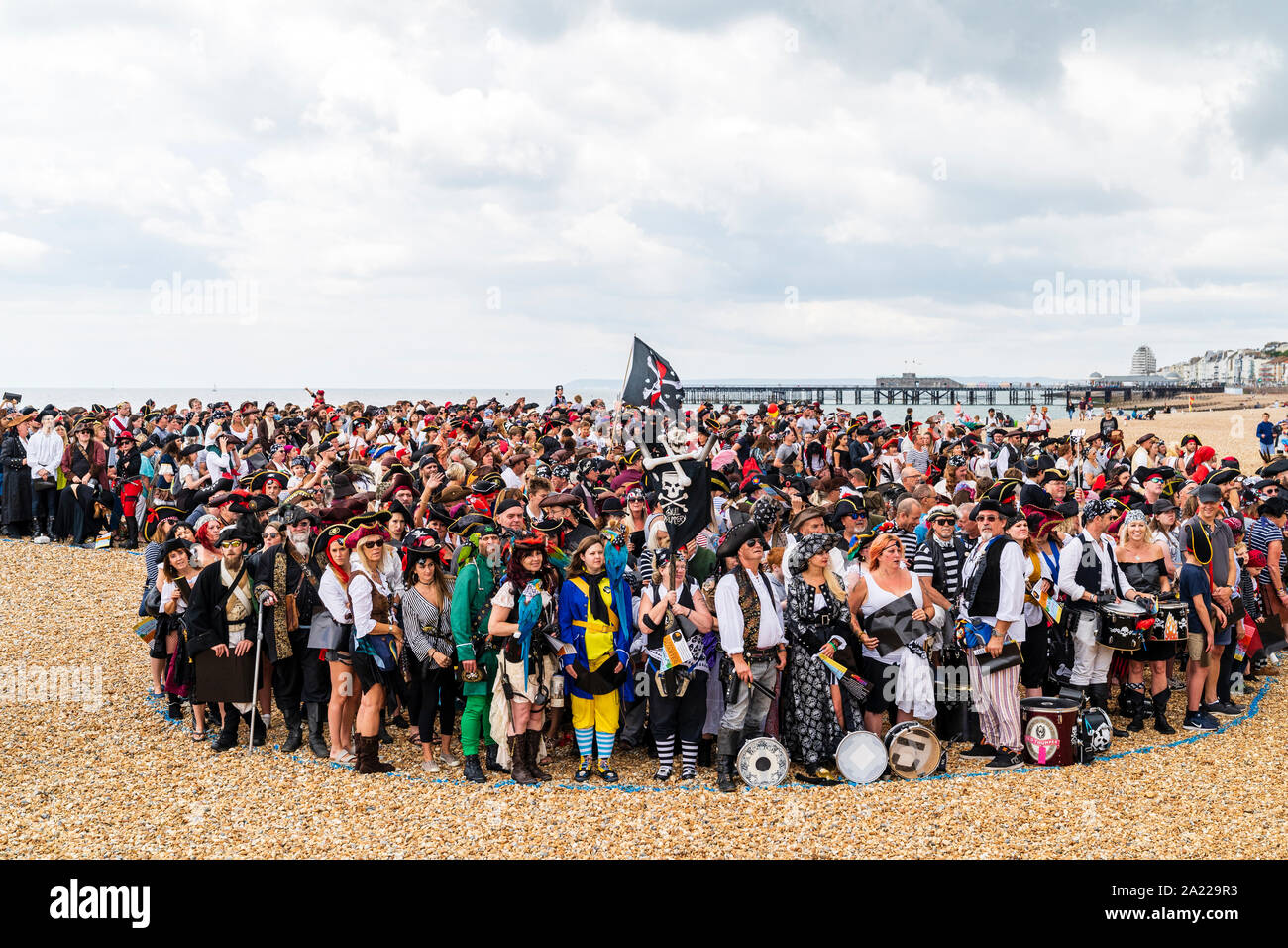 Pirate Day in Hastings, UK. Thousands of people dressed as pirates crowded into designated sectors on the beach for the world record attempt. Stock Photo
