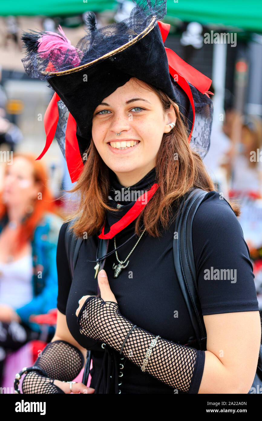 Pirate Day in Hastings UK. Close up of pretty Caucasian young woman dressed in black as pirate and smiling at viewer. Wears small nose ring Stock Photo Alamy