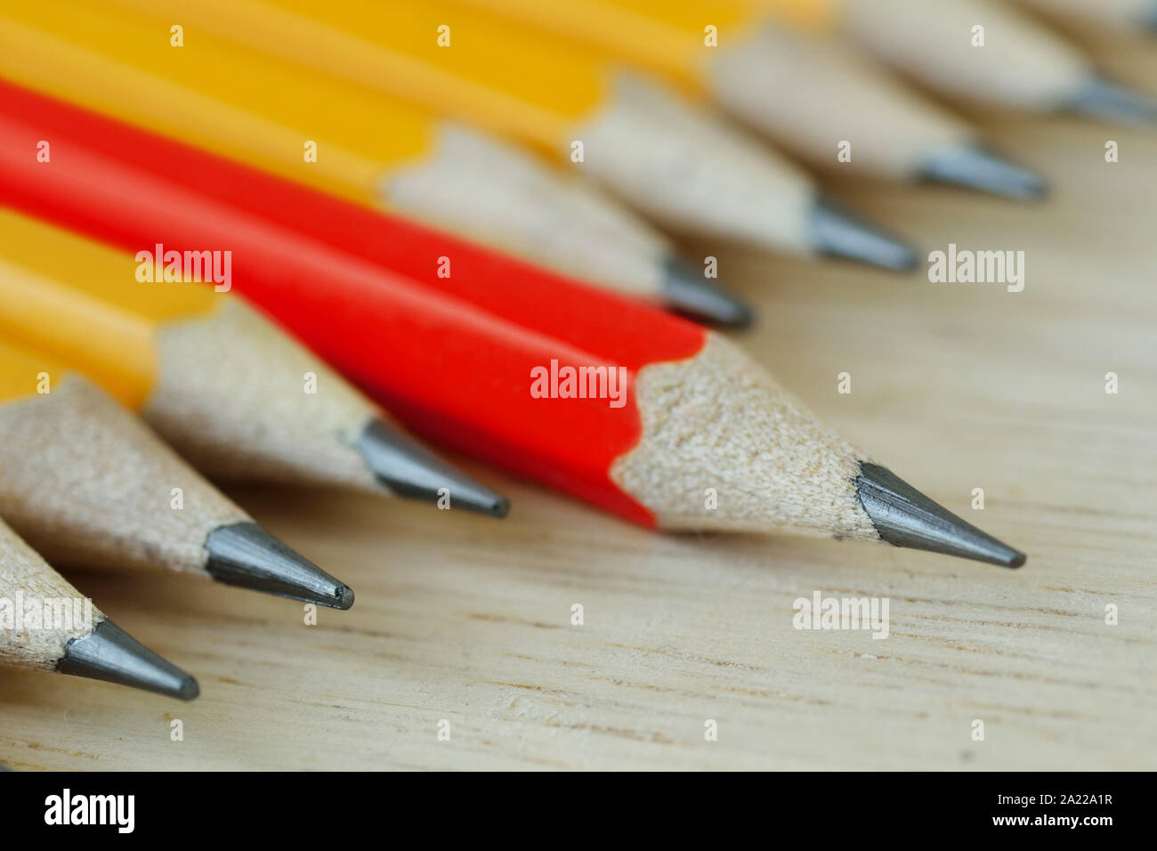 Red pencil standing out from croud of yellow pencils - Think different and leadership concept Stock Photo