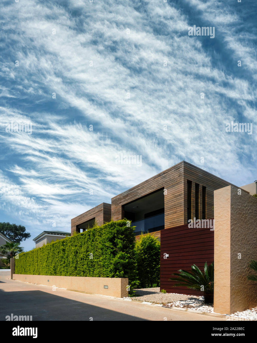 Modern houses with green plant wall on blue sky background. Actual eco