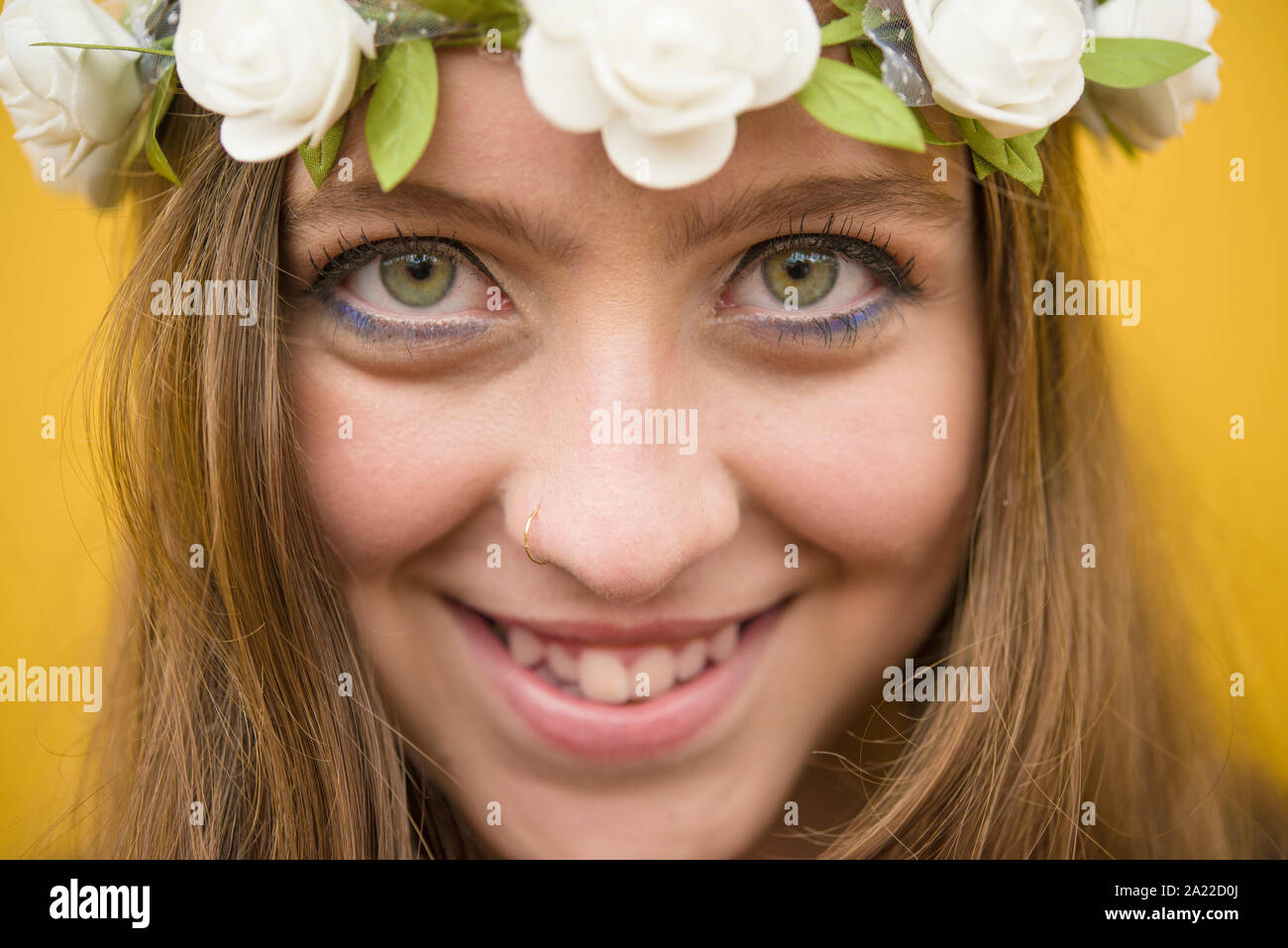 Beautiful blond girl with green eyes wearing flowery wreath Stock Photo