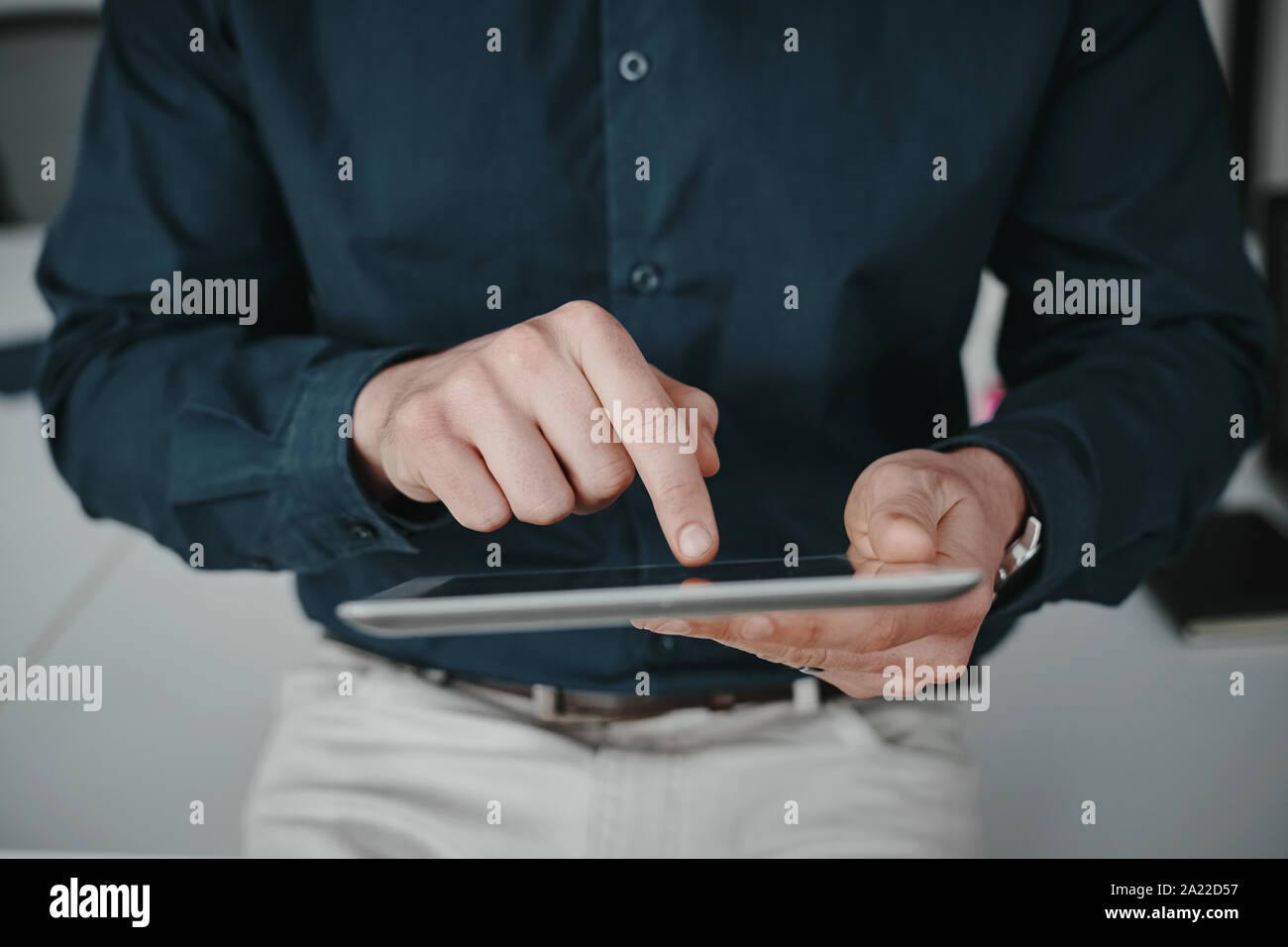 Midsection of businessman wearing shirt touching blank screen digital tablet with finger Stock Photo