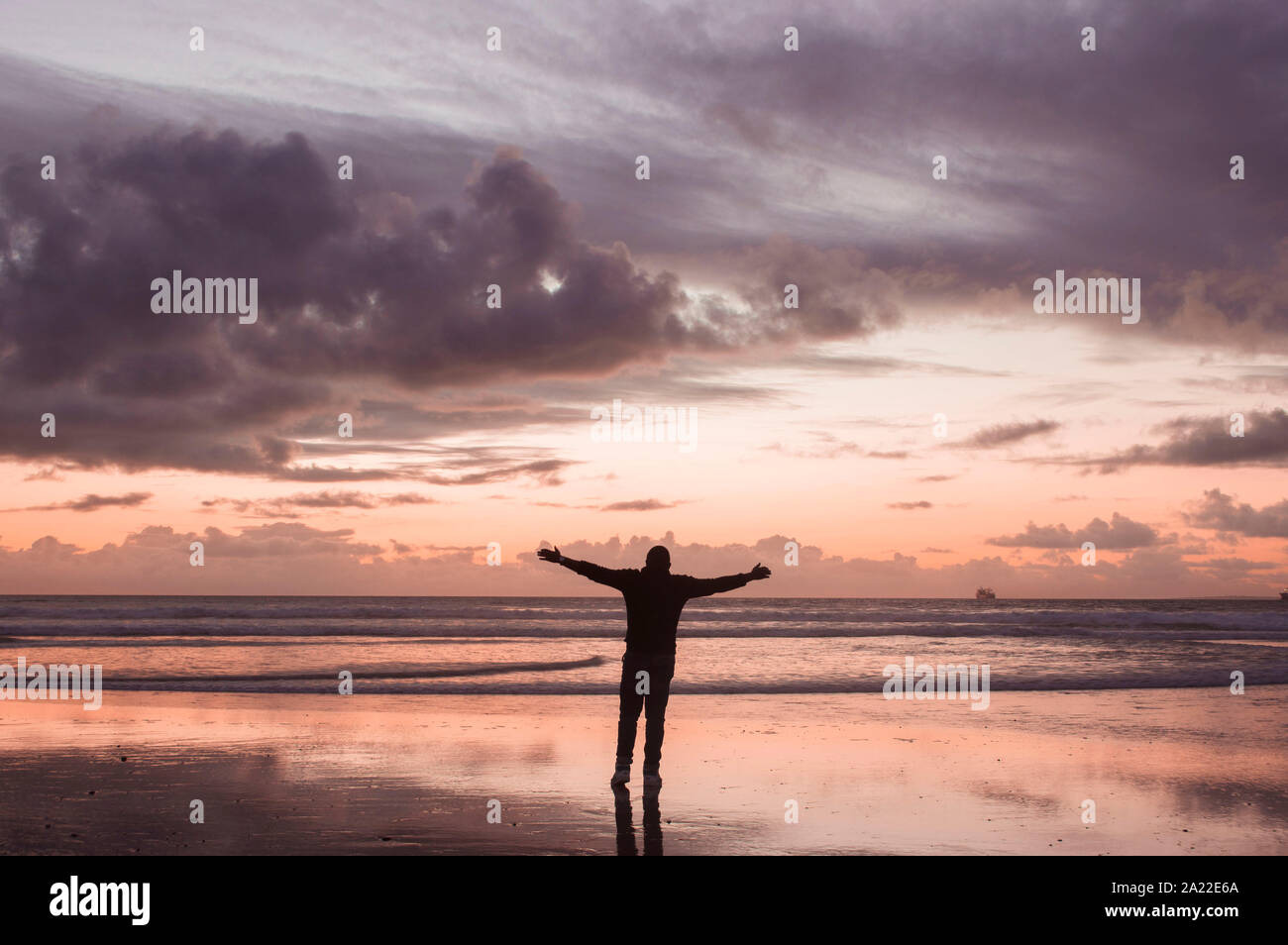 A silhouette of young man at the beach at sunset Stock Photo - Alamy