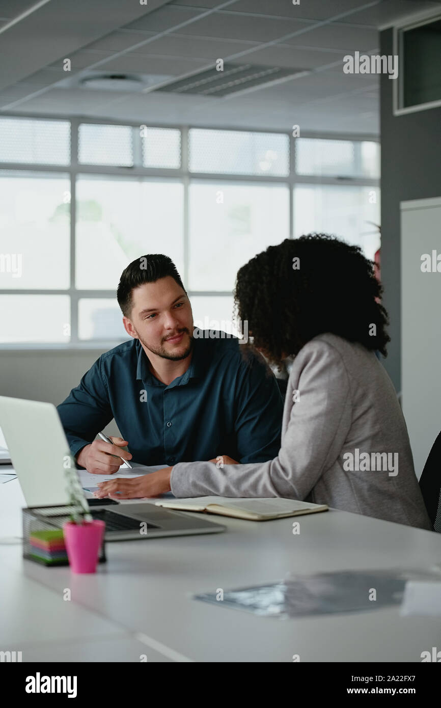 Young business team or partnership having a serious discussion at a table in the office Stock Photo