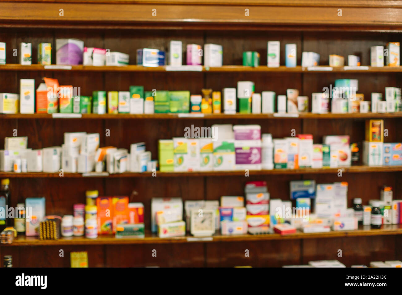 Pharmacy interior with blurred background. Wooden shelves with boxes of