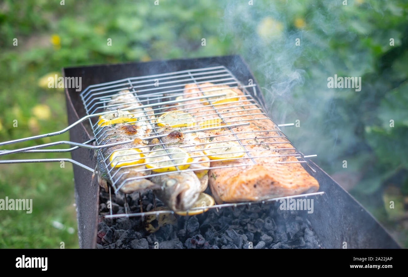 Barbecue outdoors with grilled salmon and gilt-head bream Stock Photo