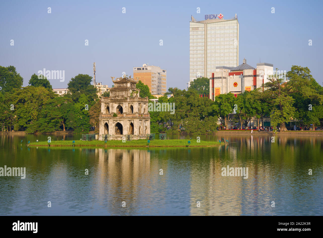 HANOI, VIETNAM - DECEMBER 13, 2015: Turtle tower on the background of modern buildings on the embankment of Hoan Kiem lake on a sunny morning Stock Photo
