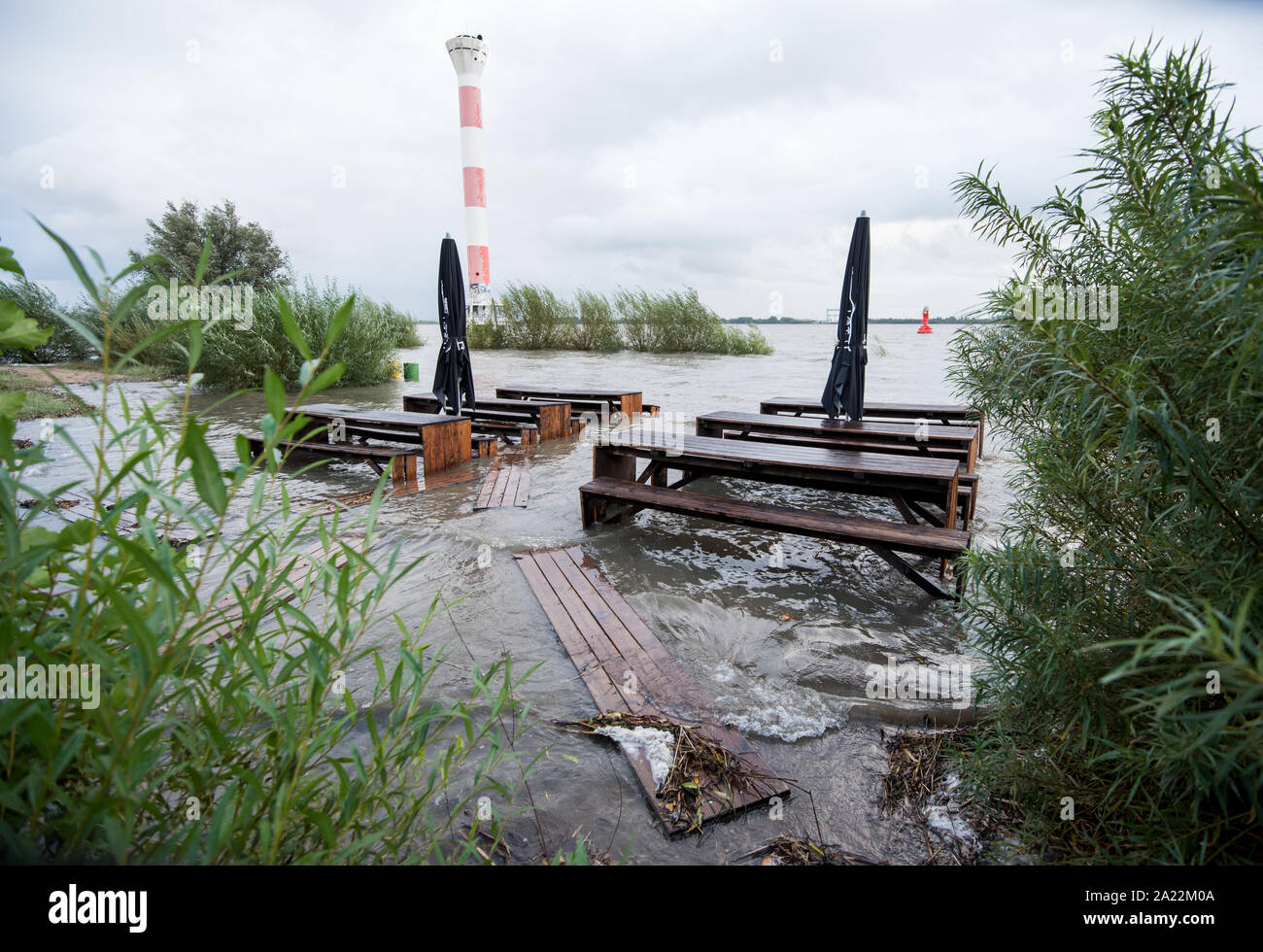 30 September 2019, Hamburg: Tables and benches of a restaurant are located in the district Blankenese during the flood on the flooded beach in the Elbe. Photo: Daniel Bockwoldt/dpa Stock Photo