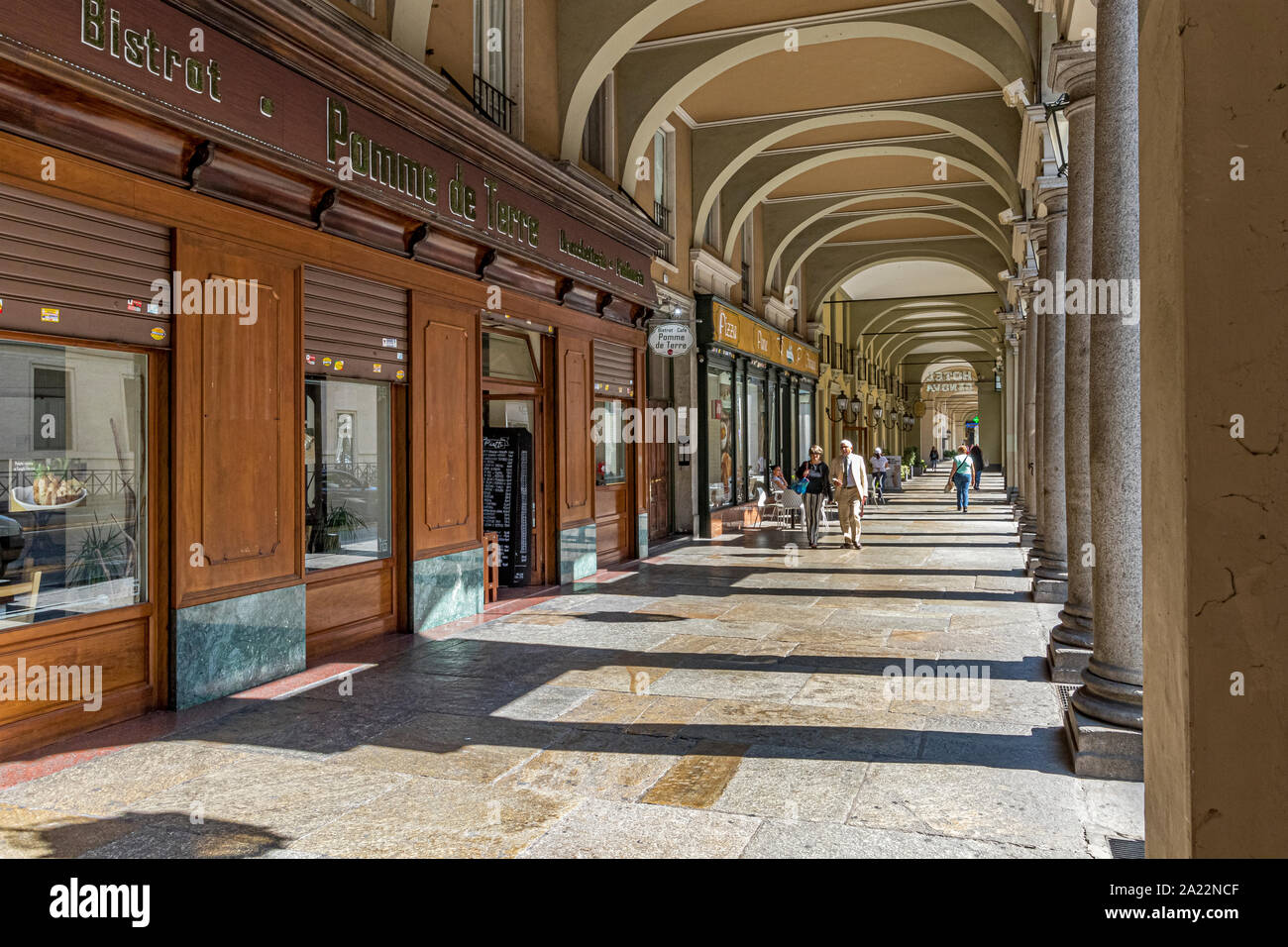 People strolling under the elegant colonnaded walkways along Via Sacchi in Turin , Italy , a city  largest pedestrian area in Europe Stock Photo