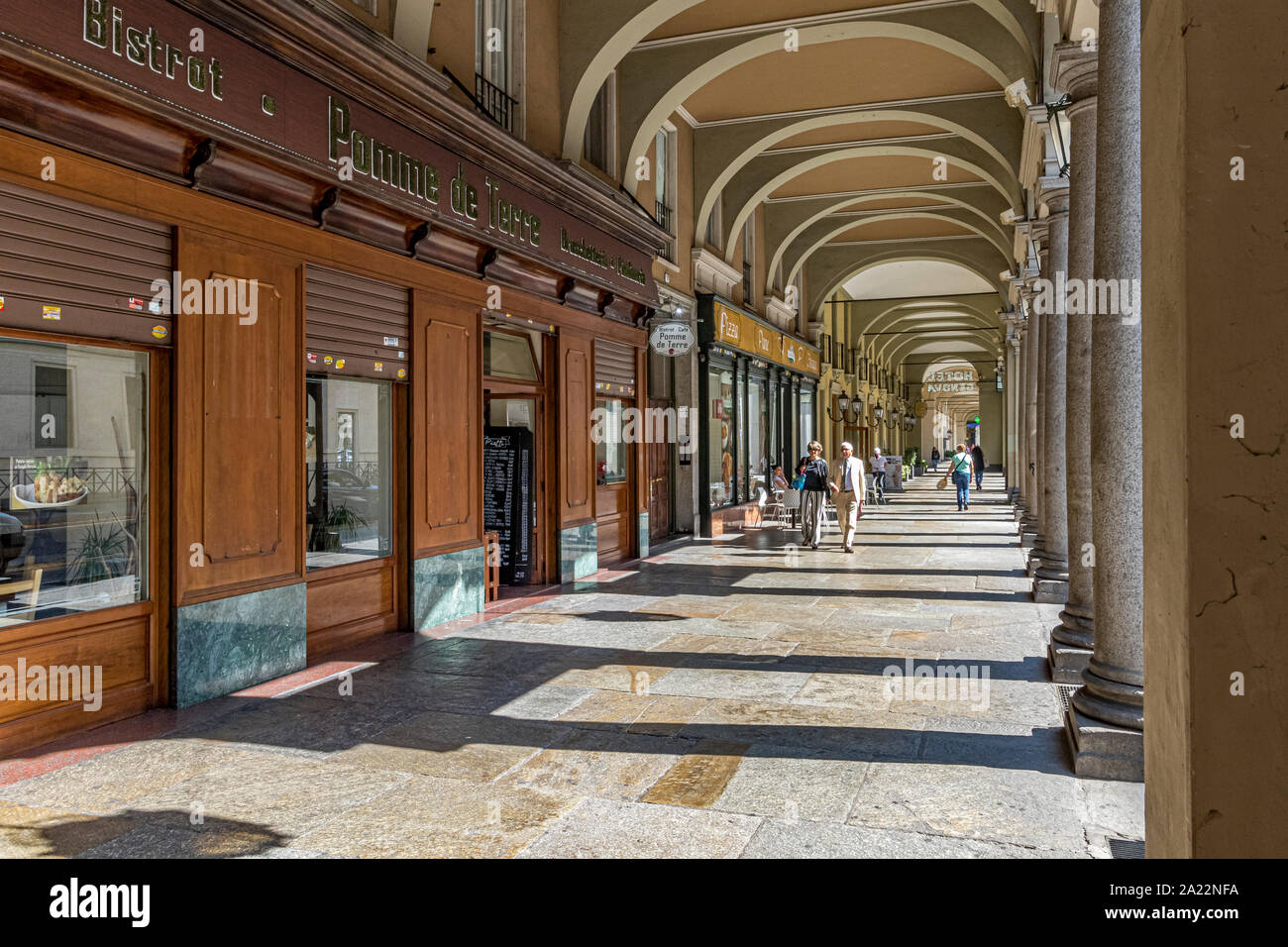 People strolling under the elegant colonnaded walkways along Via Sacchi in Turin , Italy , a city  largest pedestrian area in Europe Stock Photo