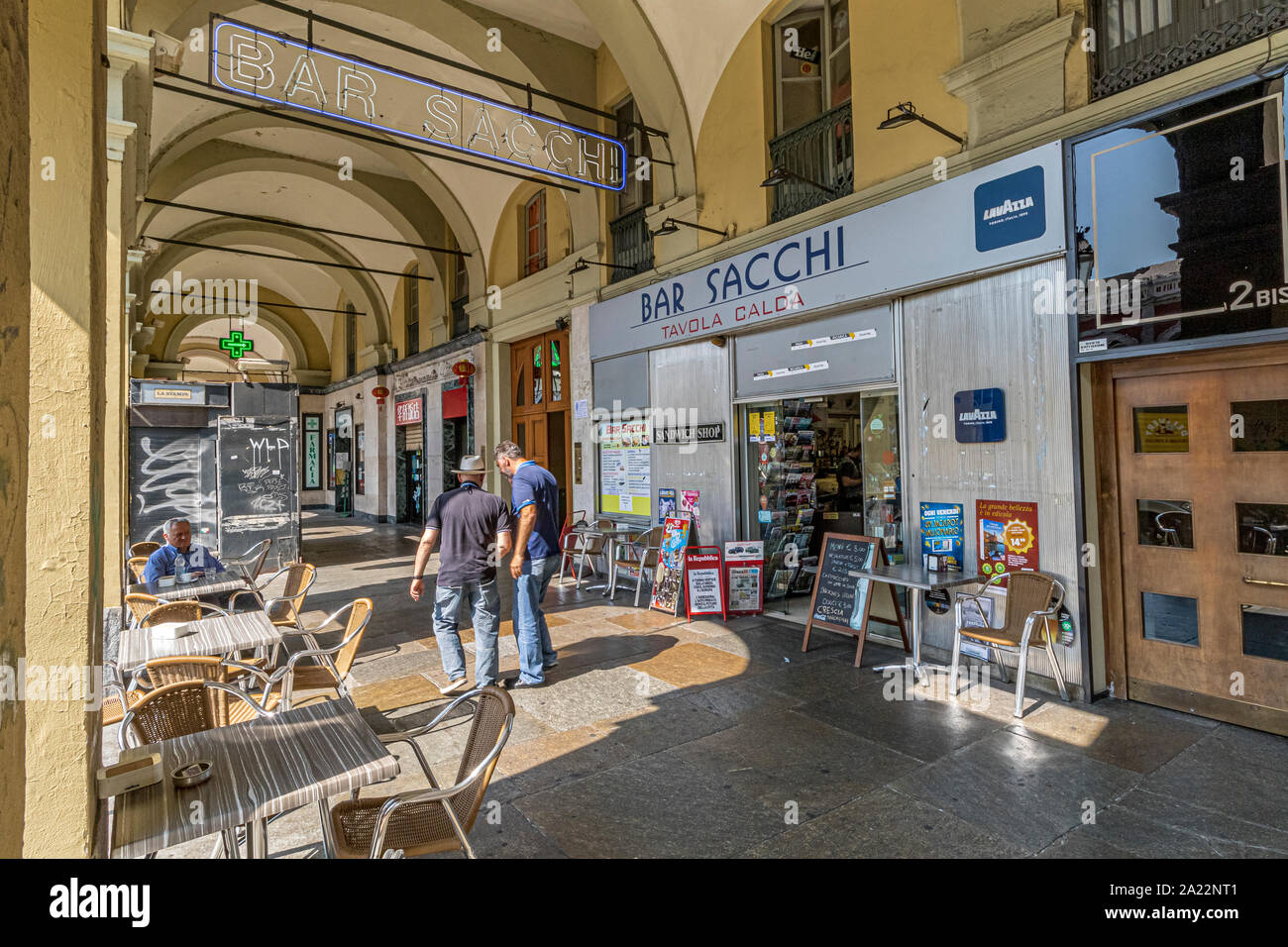 Two men having a discussion outside Bar Sacchi under the colonnaded shopping arcades along Via Sacchi ,Turin ,Italy Stock Photo