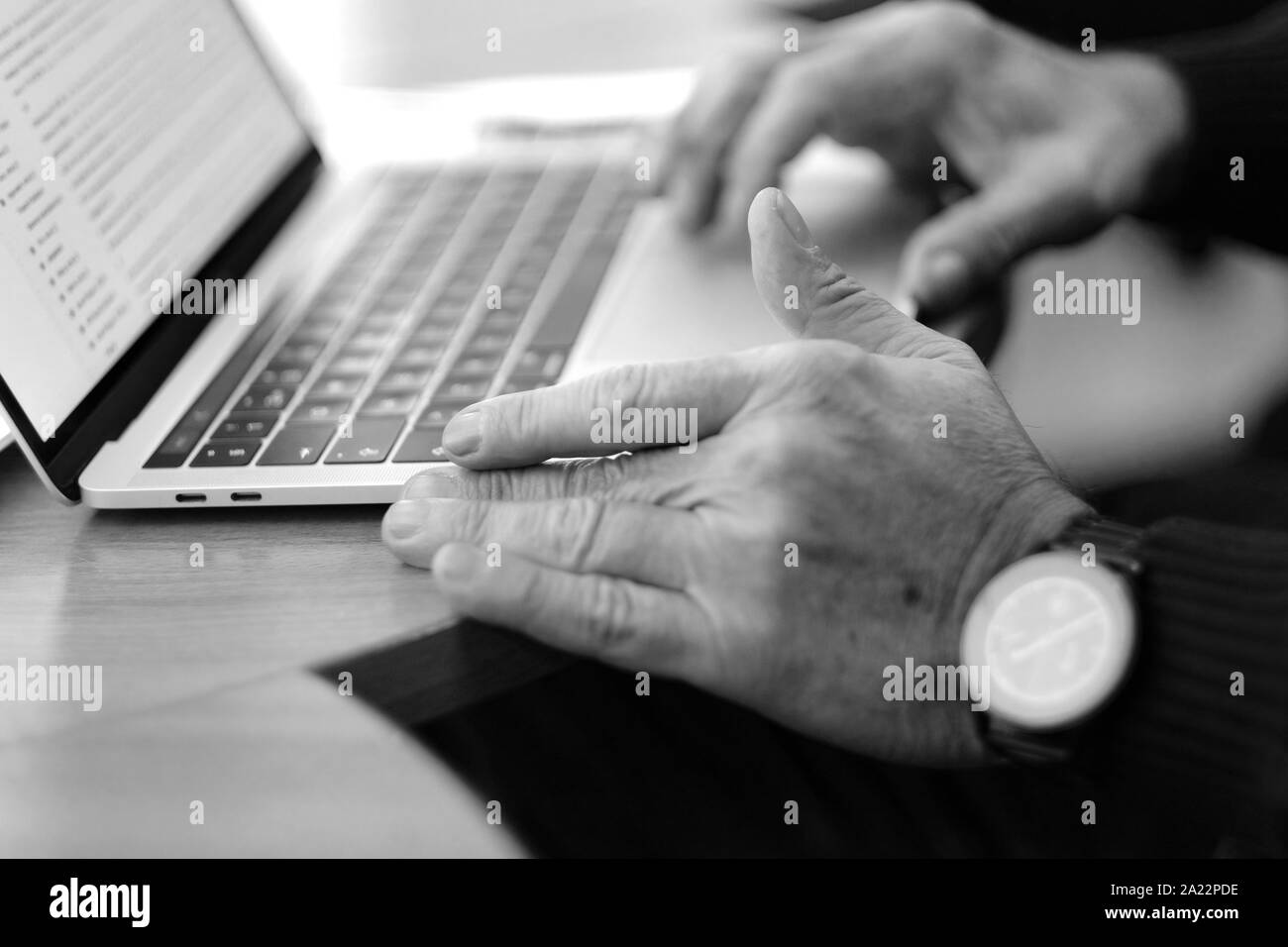 Man's hand brush on the notebook cursor control button while working with information Stock Photo