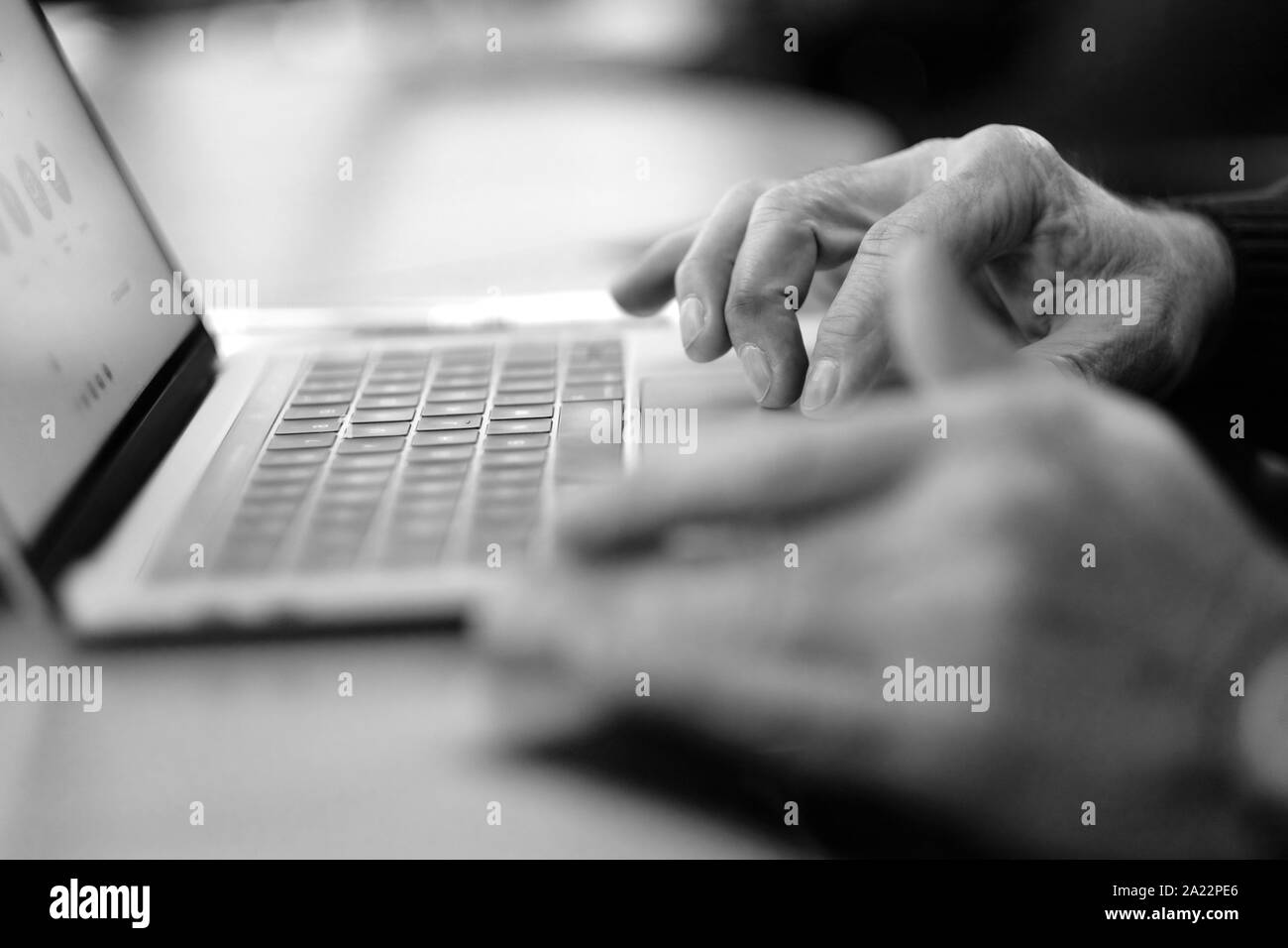 Man's hand brush on the notebook cursor control button while working with information Stock Photo