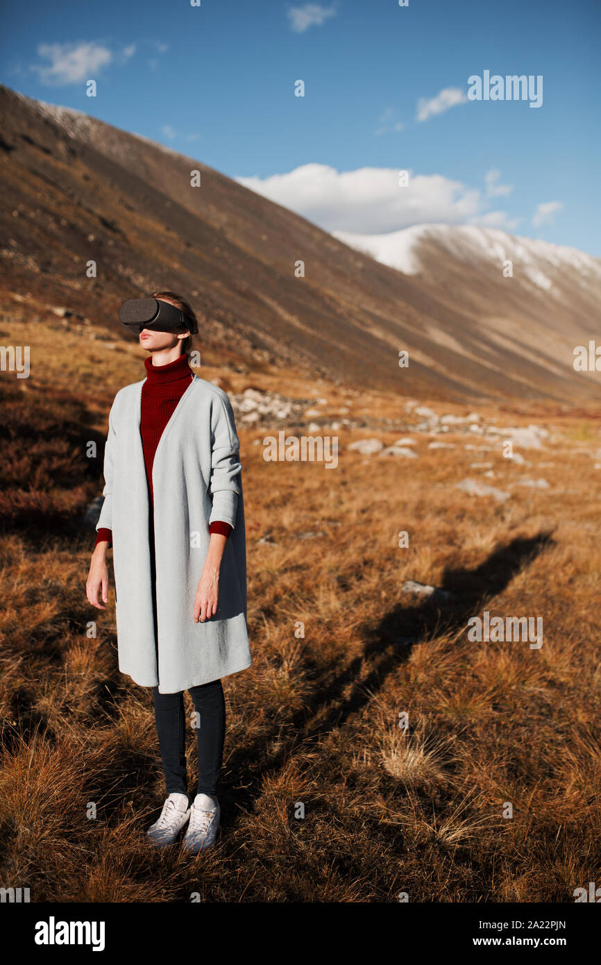 Woman in virtual reality. Mountain landscape at background. Stock Photo