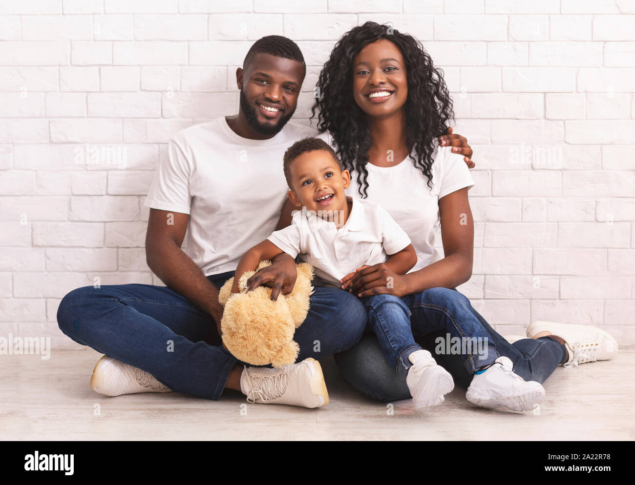 Family Bonds. Young African American Parents And Son Sitting On Floor