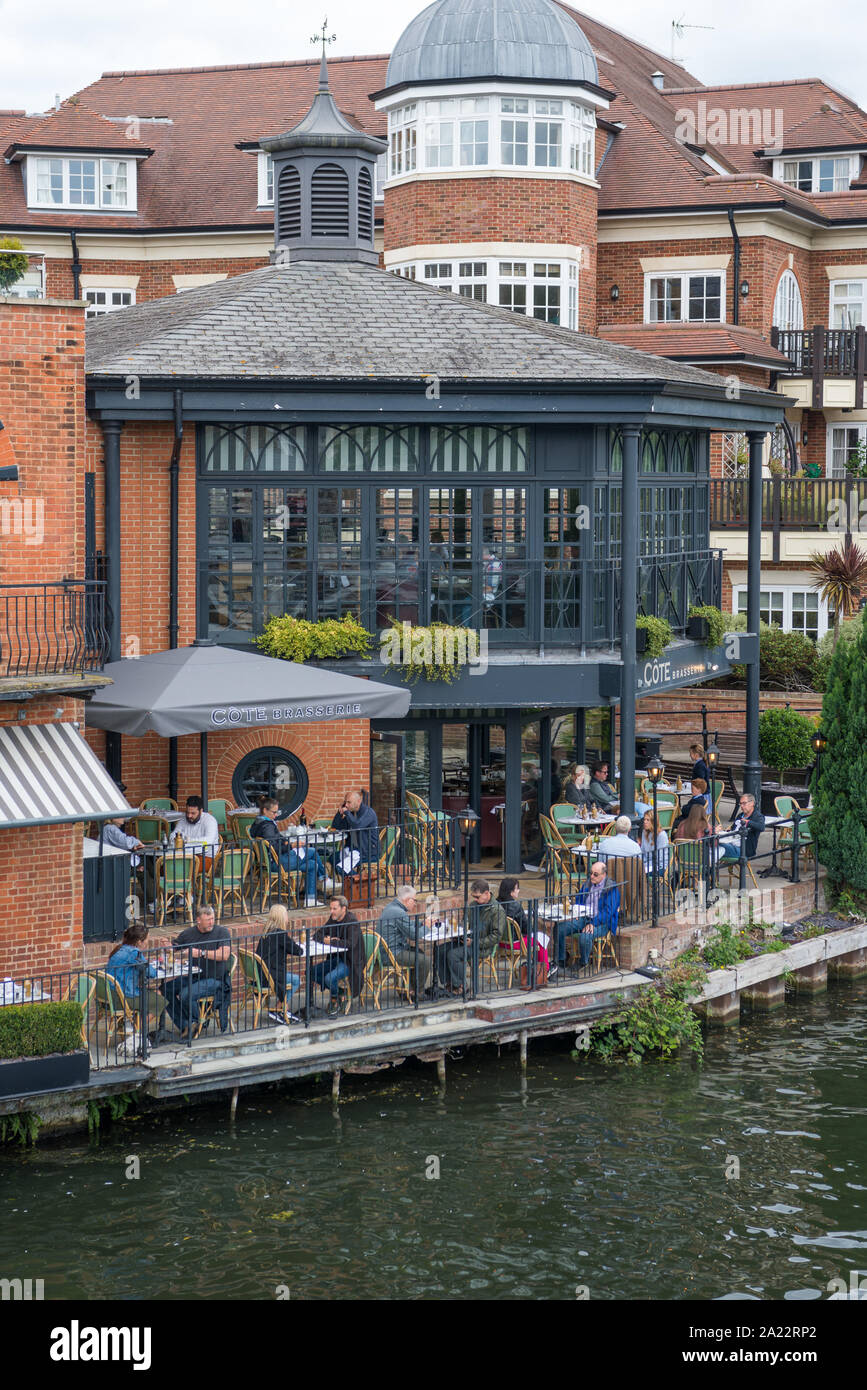 People socialising and enjoying food and refreshments at the Cote Brasserie French restaurant on the bank of the River Thames at Eton, Berkshire, UK Stock Photo
