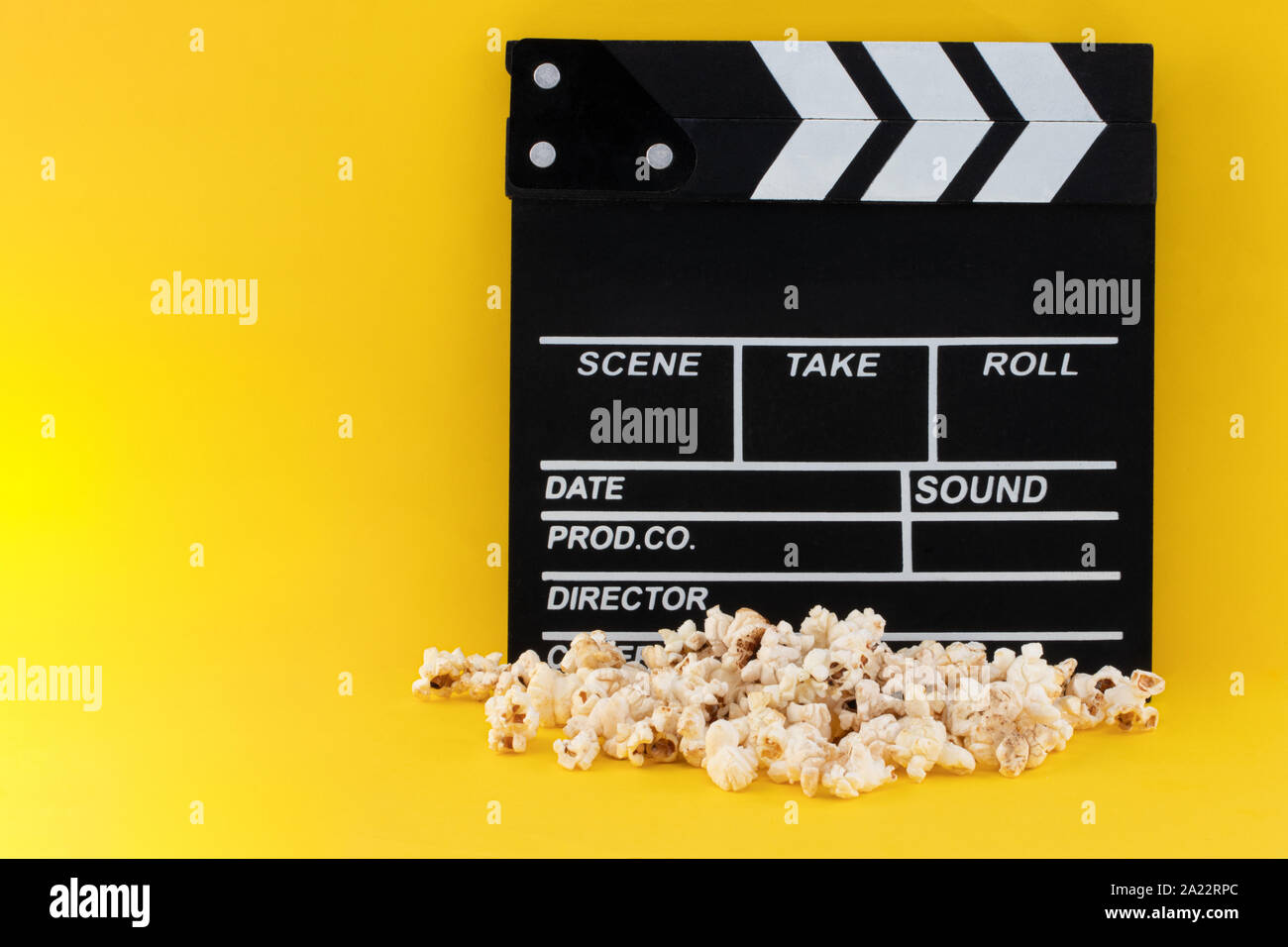 Popcorn and clapperboard on colorful background. Stock Photo