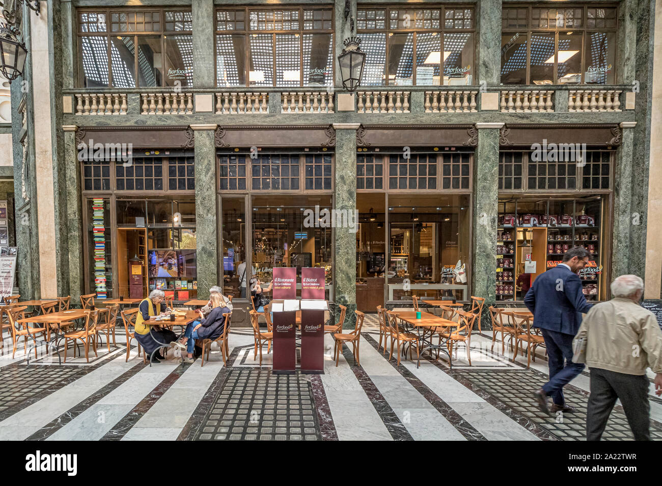 People sitting at tables eating food in the indoor ,art deco,glass ceilinged  arcade ,Galleria San Federico in Turin ,Italy Stock Photo