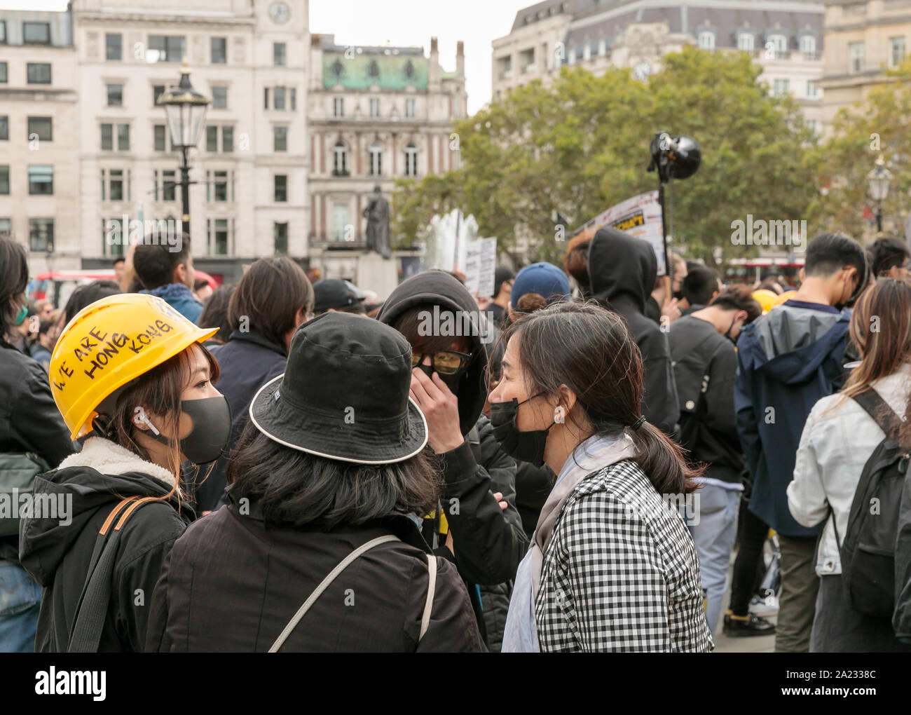 Protestor wearing face mask and yellow hard hat bearing the words 'We are Hong Kong' at demonstration against Chinese rule in Hong Kong, Trafalgar Square, London, 28th September 2019. Hundreds pf people gather after marching from the chinese consulate Stock Photo