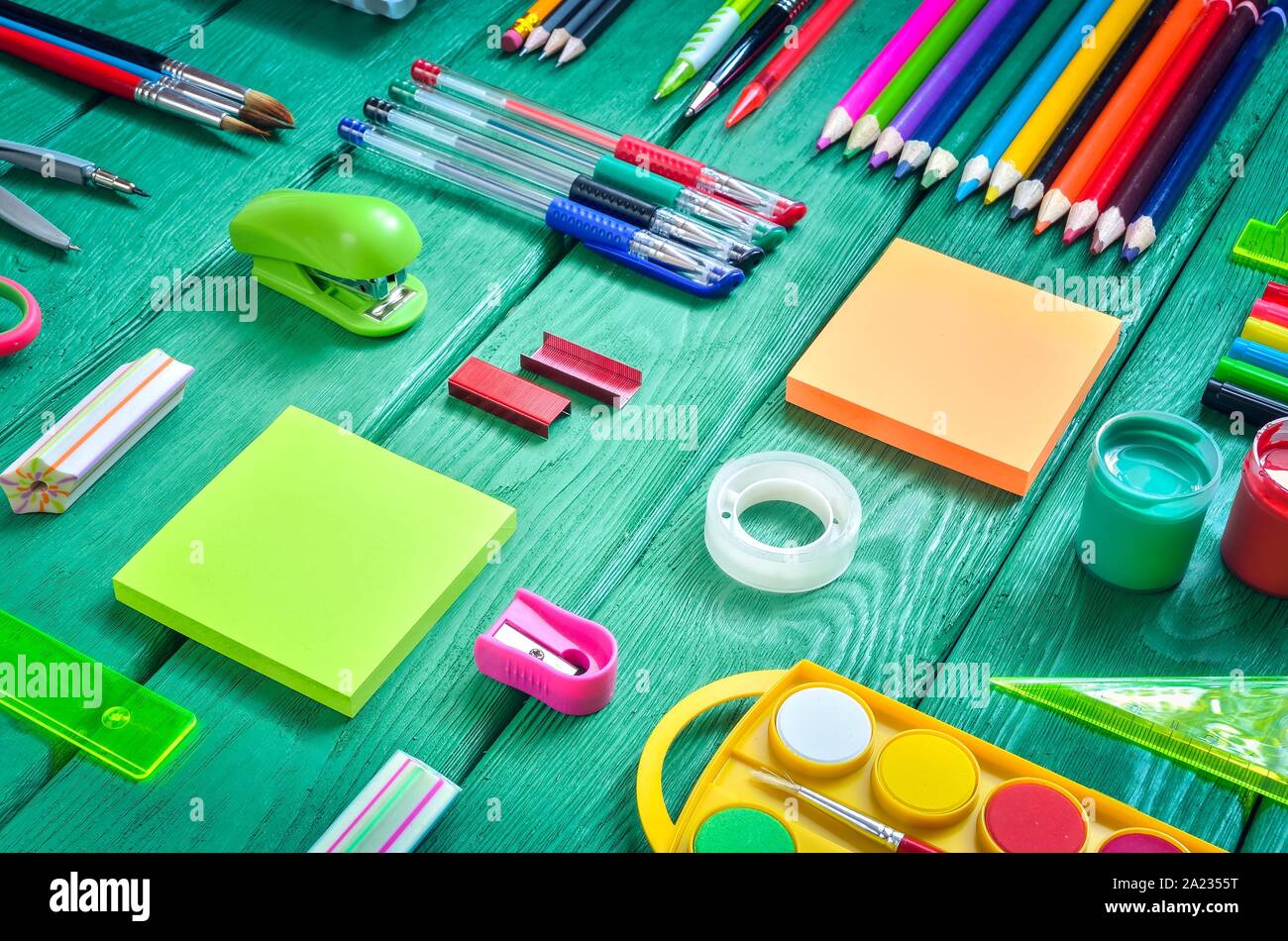 Creative school concept. Arranged school accessories on a green desk. Stock Photo