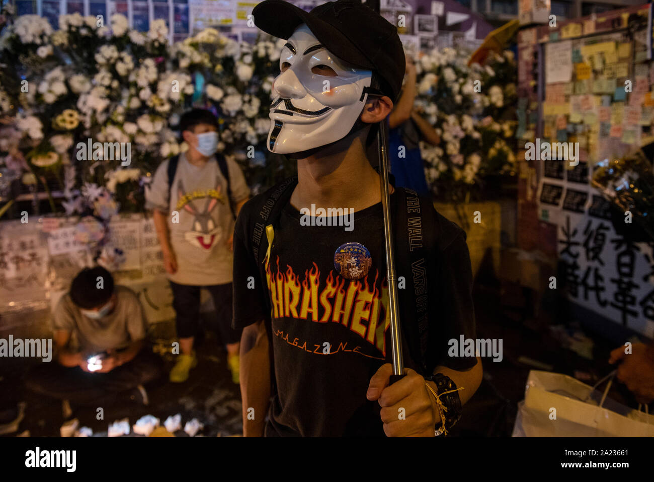 A demonstrator wears an Anonymous mask in front of police station in Mong Kok a day before Chinese National Day.Pro-Democracy protester have been protesting across Hong Kong for the past few months calling for the government to meet their demands including setting up an independent inquiry into police misconduct and abuse of power over the past few months of protest in Hong Kong, Also calling for universal suffrage. Stock Photo