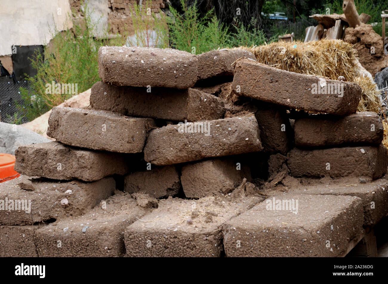 Adobe bricks and the straw used to make them at a semi abandoned restoration project at The Plaza, Ranchos de Taos, New Mexico. Stock Photo