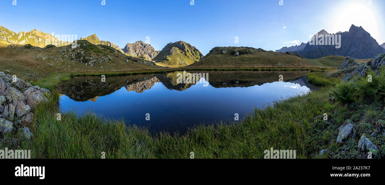 panorama landscape with clear lake in the mountains at sunrise huge rocks and Alpika and reflecting of blue sky and white clouds in Abkhazia in the Ca Stock Photo