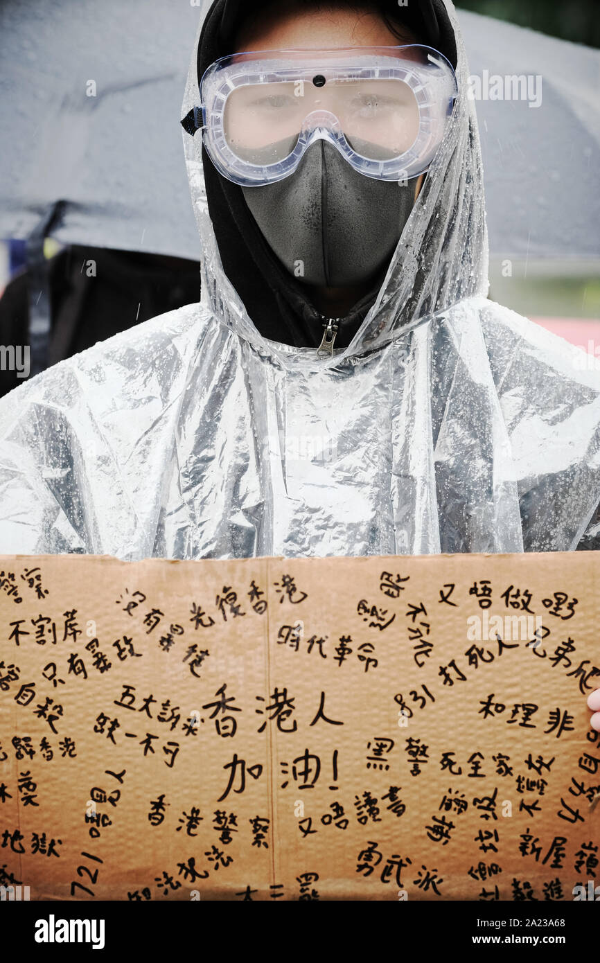Hong Kong protester wearing face mask and goggles with placard seen September 2019 Stock Photo