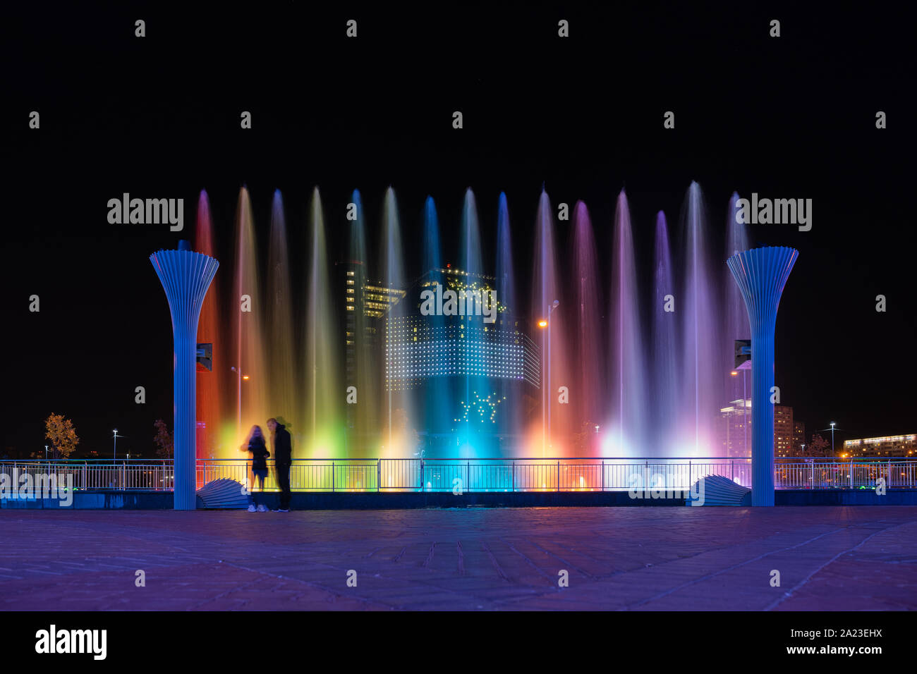 Brightly lit fountain in the evening im Minsk, Belarus. There is a National Library of Belarus behind it. Stock Photo