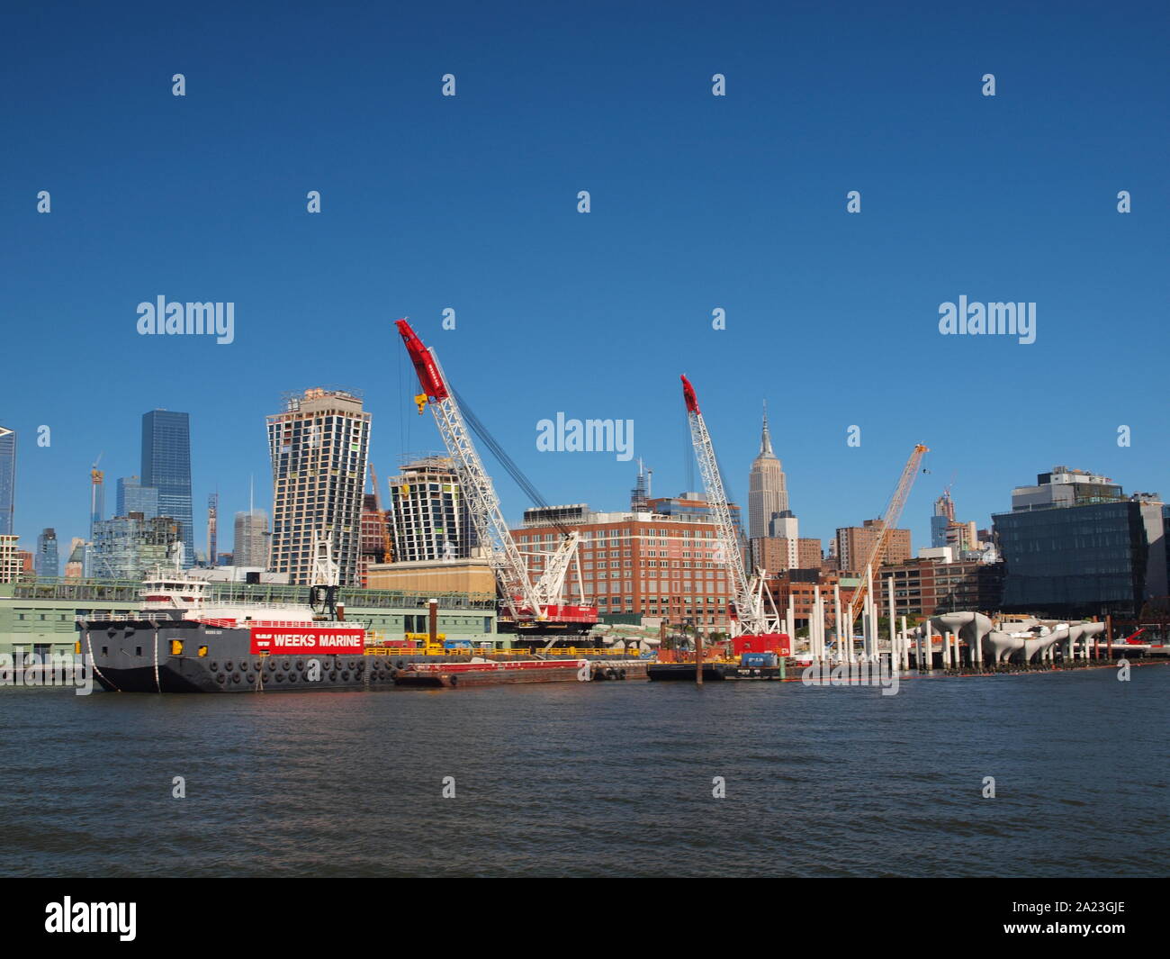 New Yok harbor and piers on the Manhattan shoreline with large construction ship and cranes Stock Photo