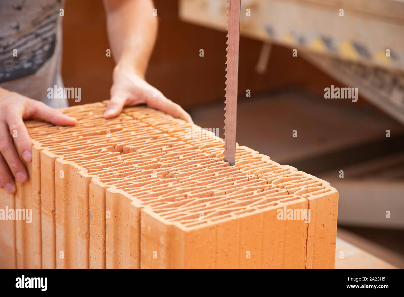Bricklayer is cutting a brick with an electrical saw Stock Photo