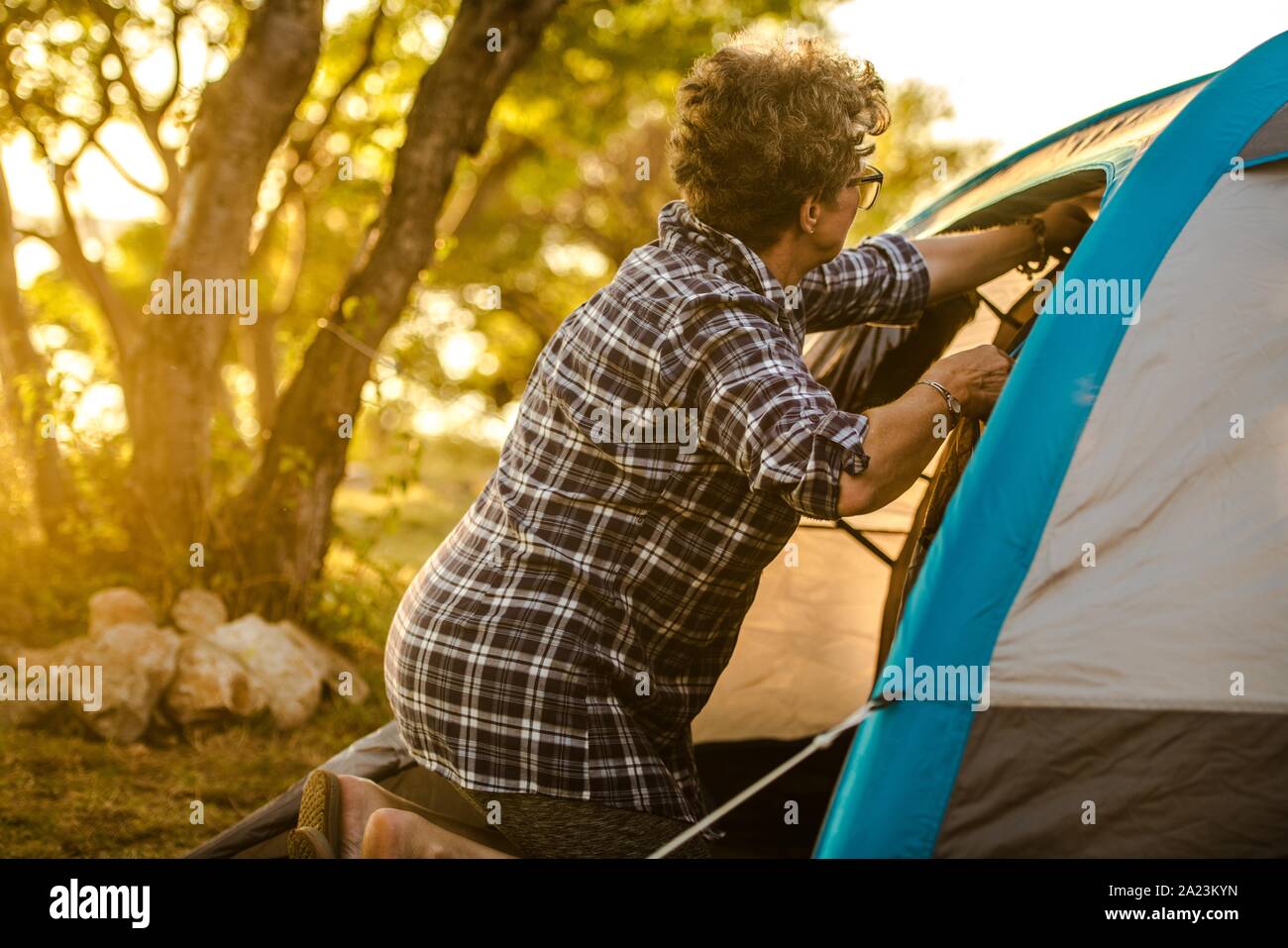 Caucasian Retired Woman in Her 60s Enjoying Summer Vacation on the Go with Small Tent. Retirement Theme. Stock Photo