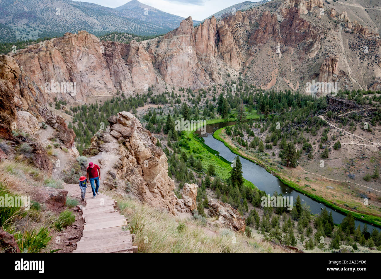 On the Misery Ridge Trail at Smith Rock, a father and young son hike up the steps high above the Crooked River, near Bend, Oregon. Stock Photo
