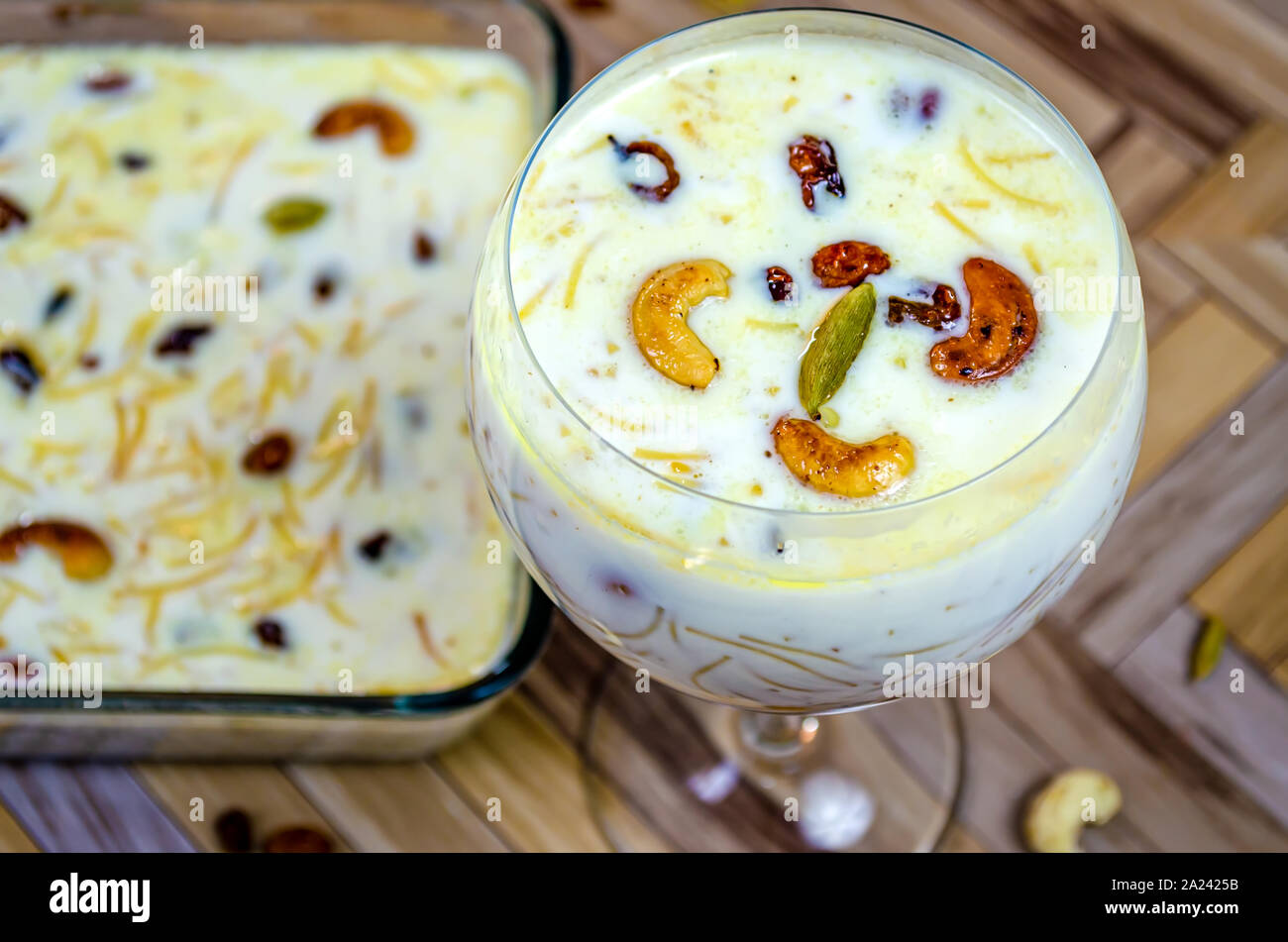 Closeup of Vermicelli Kheer in a Balloon Glass garnished with Cashew, raisins & cardamom. Stock Photo