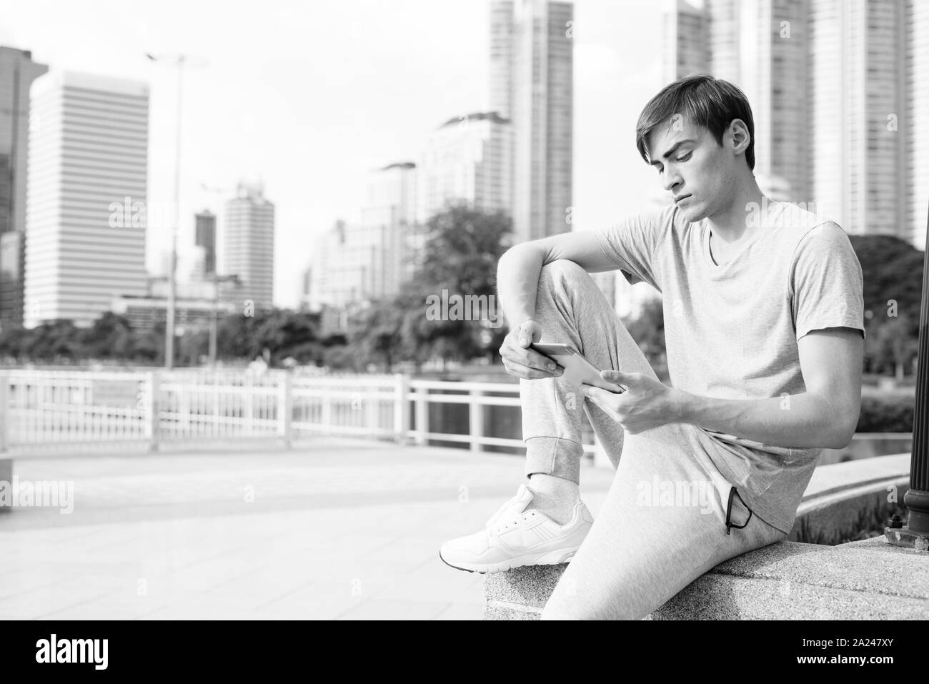 Young handsome man using digital tablet while relaxing at the park Stock Photo