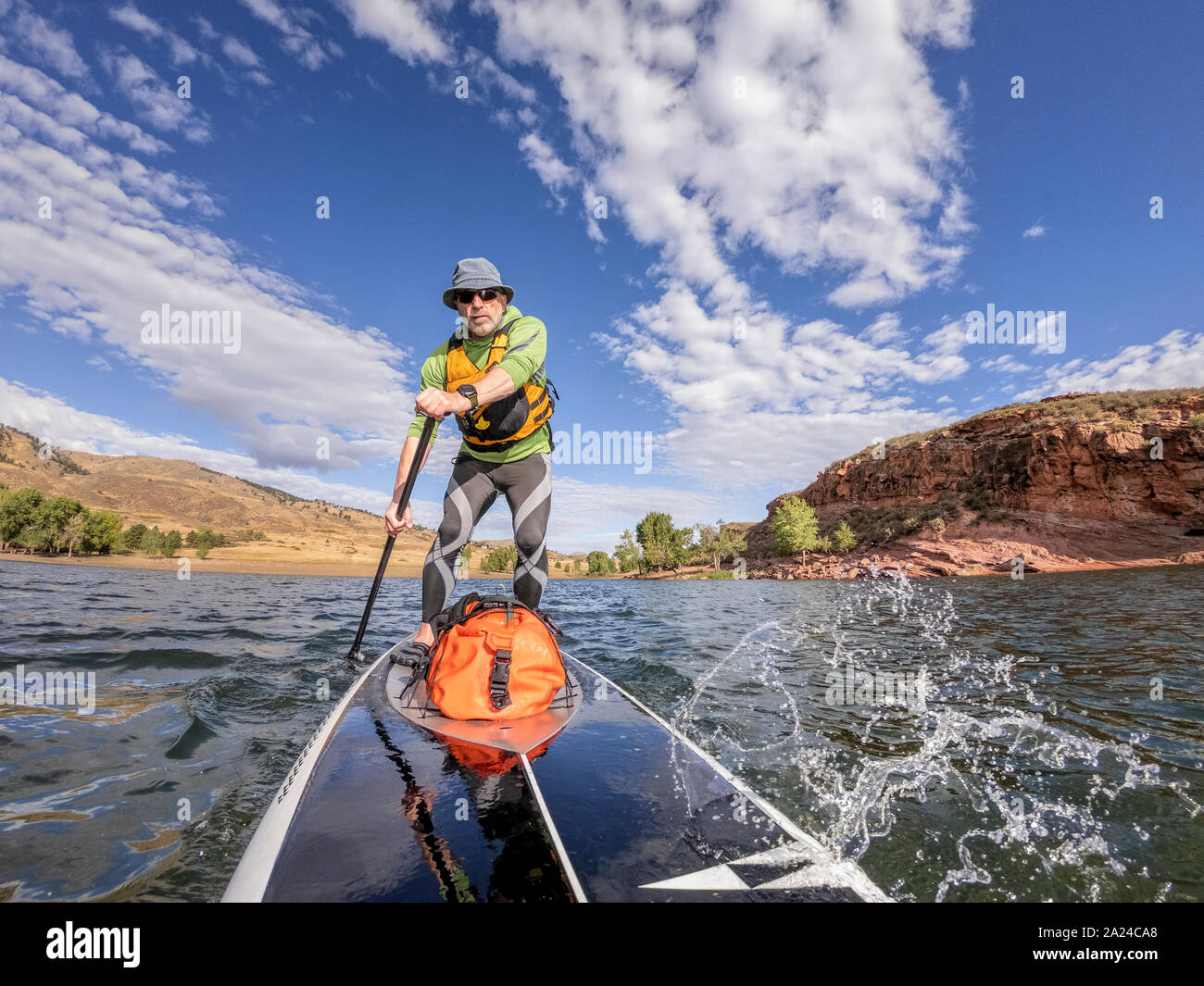 senior man paddling a stand up paddleboard against head wind on mountain lake - Horsetooth Reservoir , Colorado, in early fall scenery Stock Photo