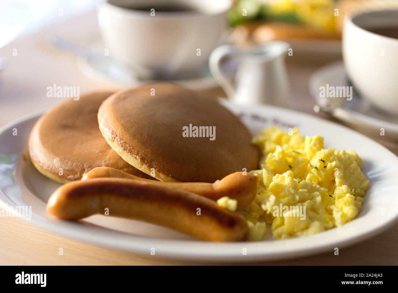Close Up Breakfast With Sausages Bread Scrambled Eggs And Pancakes On White Plate Macro Stock Photo Alamy