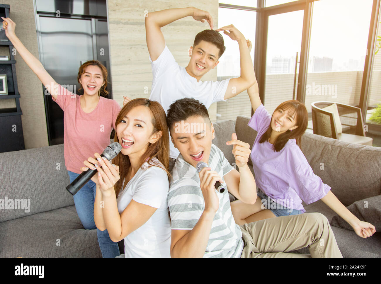 Group of friends playing karaoke at home Stock Photo Alamy