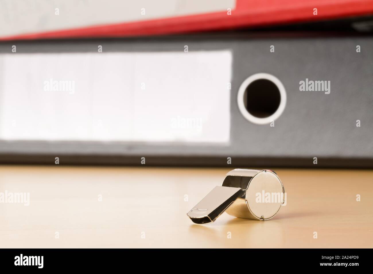 Chrome whistle in front of folders with confidential top secret