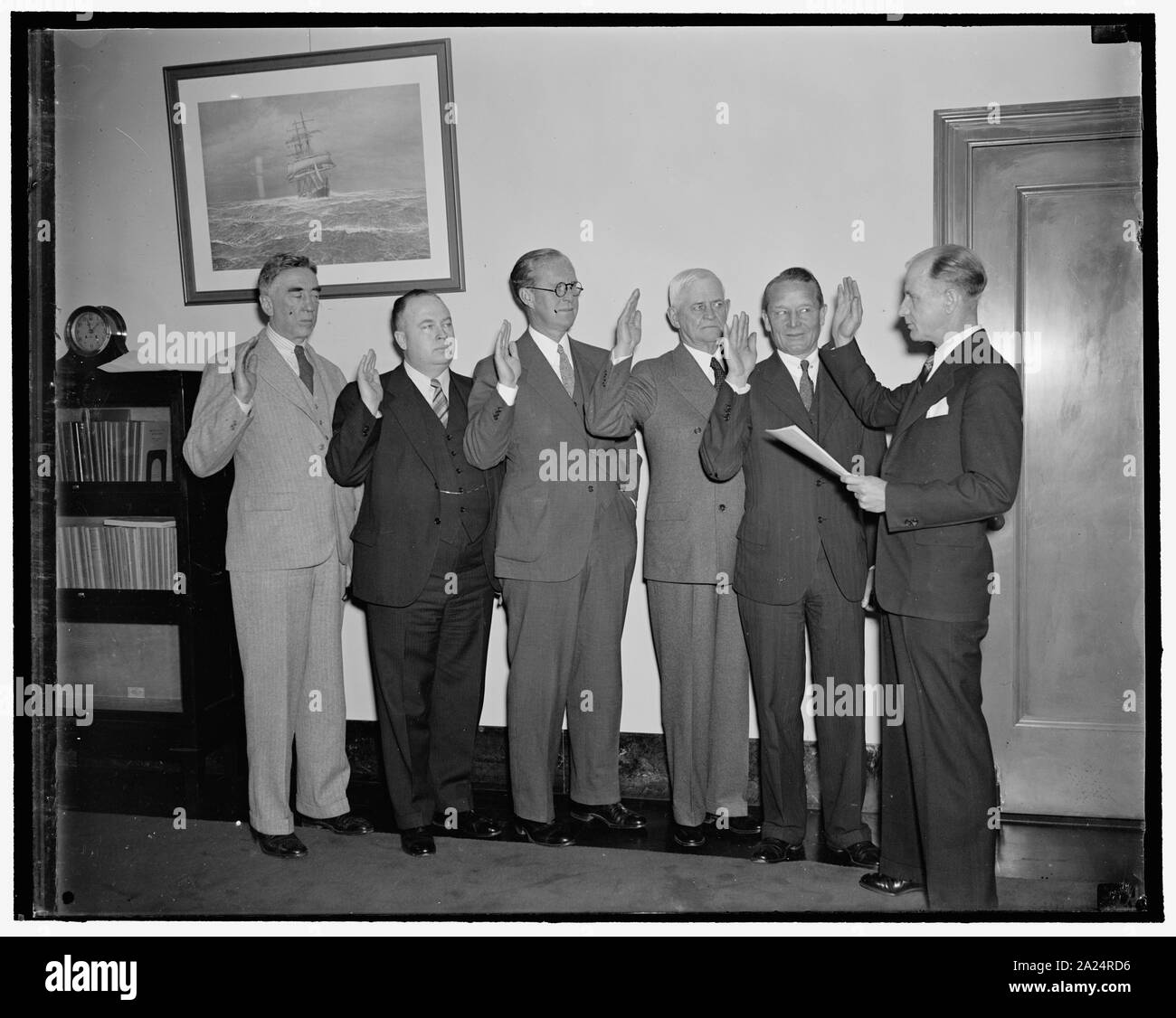 Permanent Maritime Commission sworn-in. Washington, D.C., April 14. The permanent five-man Maritime Commission as sworn-in this morning after confirmation by the Senate yesterday. Left to right at the ceremony: Thomas M. Woodward of Penna., Edward C. Moran, Jr., of Me., Chairman of the Commission Joseph P. Kennedy, and Rear Admirals Henry A. Wiley and Emory S. Land as they were sworn-in as a group by G.W. Anderson, Chief of the Personnel Section of the U.S. Maritime, 4/16/1937 Stock Photo