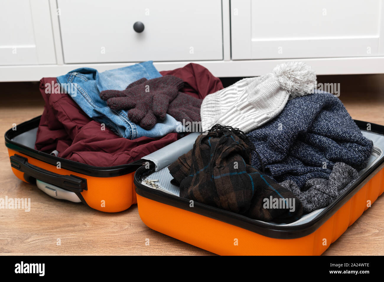 Traveler suitcase full of clothes at cozy modern apartment Stock Photo Alamy