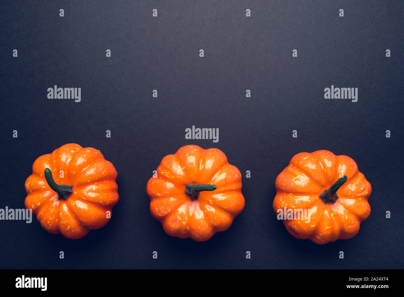Dark background with three pumpkins Stock Photo - Alamy