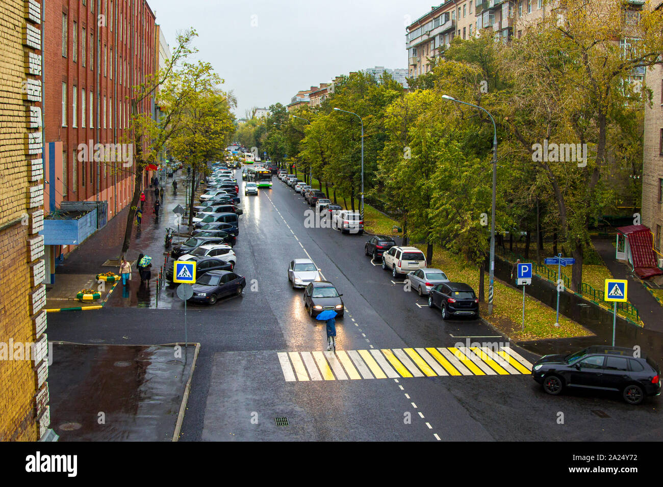 calm city street with cars and pedestrians in the rain Stock Photo - Alamy