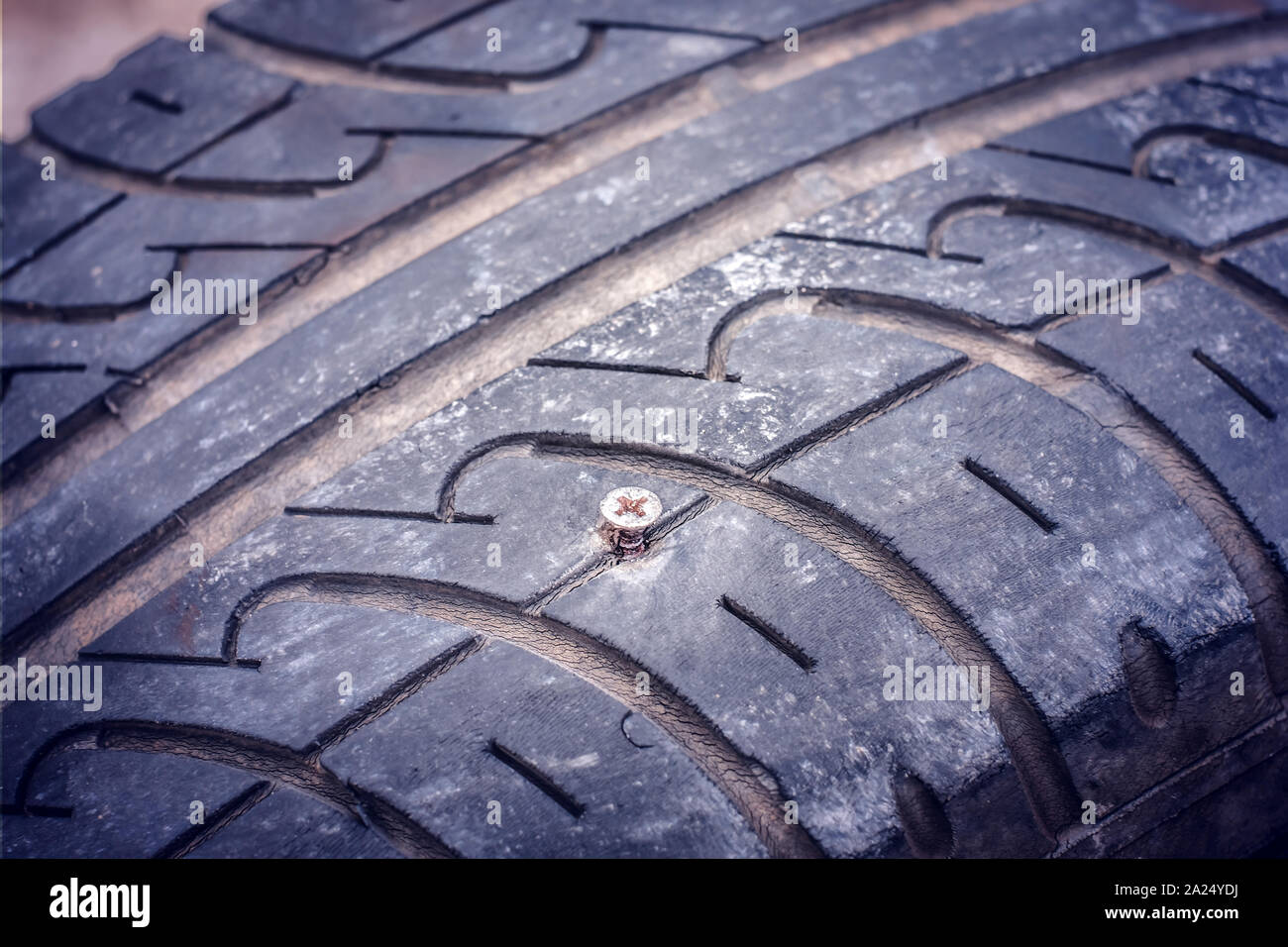 Closeup of flat car tire punctured with a screw Stock Photo