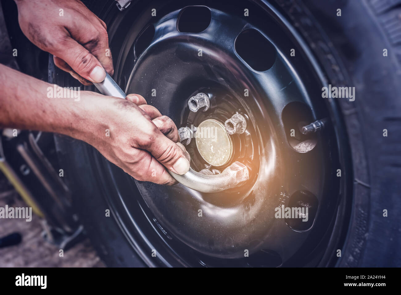 car tire change, hands on wrench closing screws after changing flat tire Stock Photo Alamy
