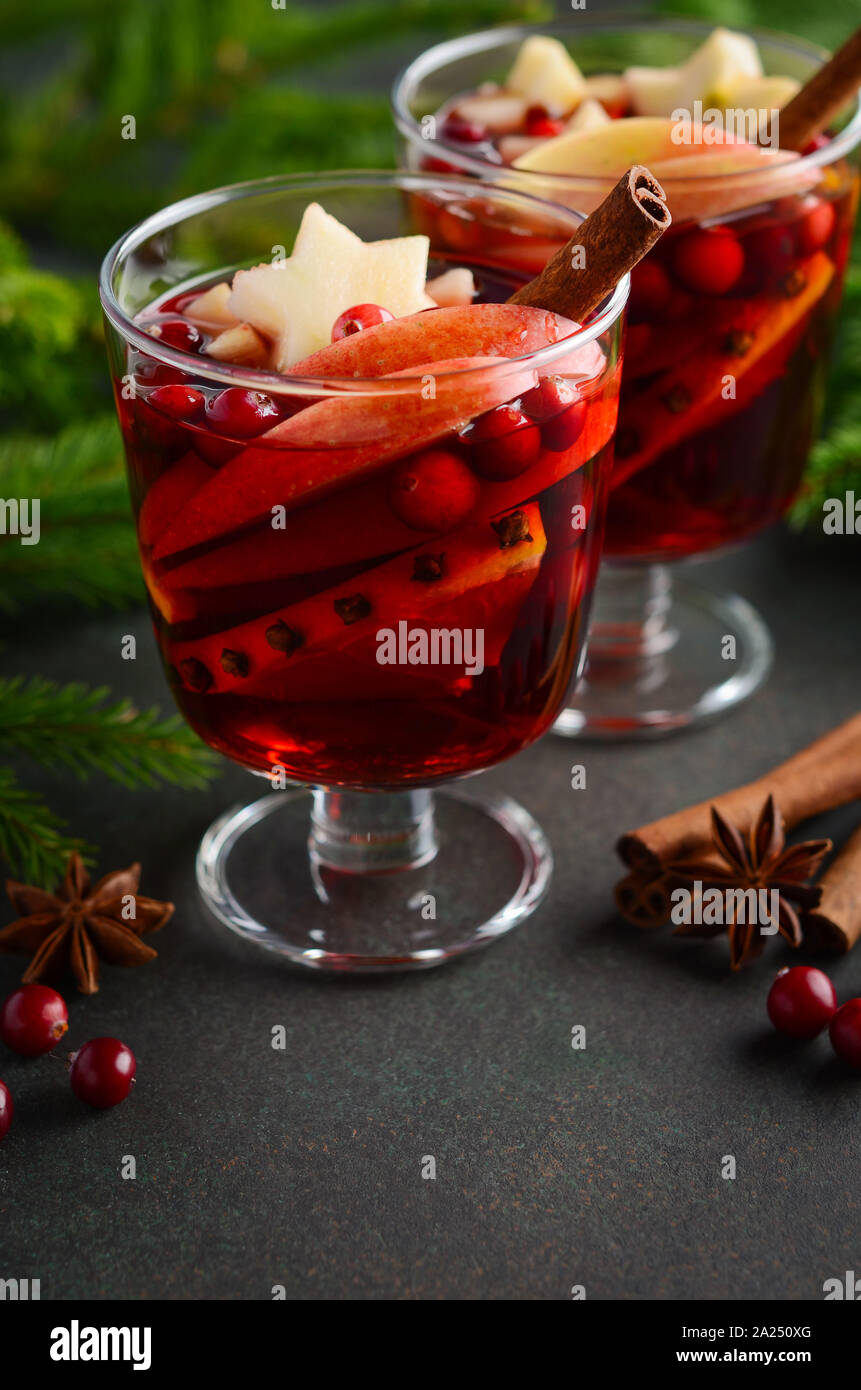 Christmas Mulled Wine with Apple, Orange and Cranberries. Holiday Concept Decorated with Fir Branches, Cranberries and Spices. Stock Photo
